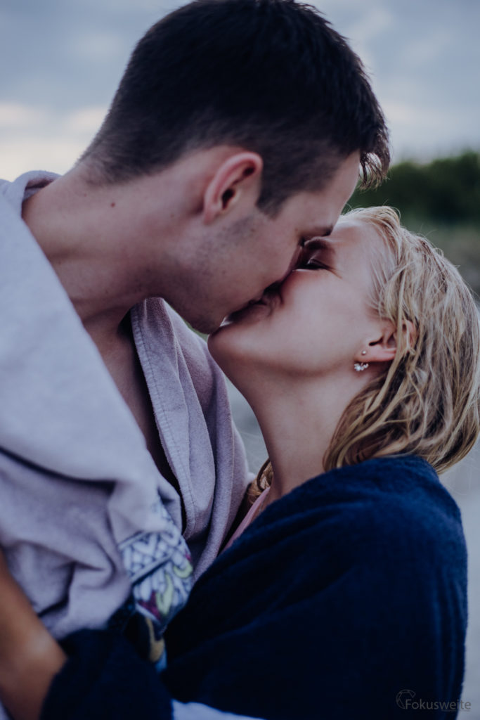 Paarfotoshooting am Strand kuscheln im Handtuch